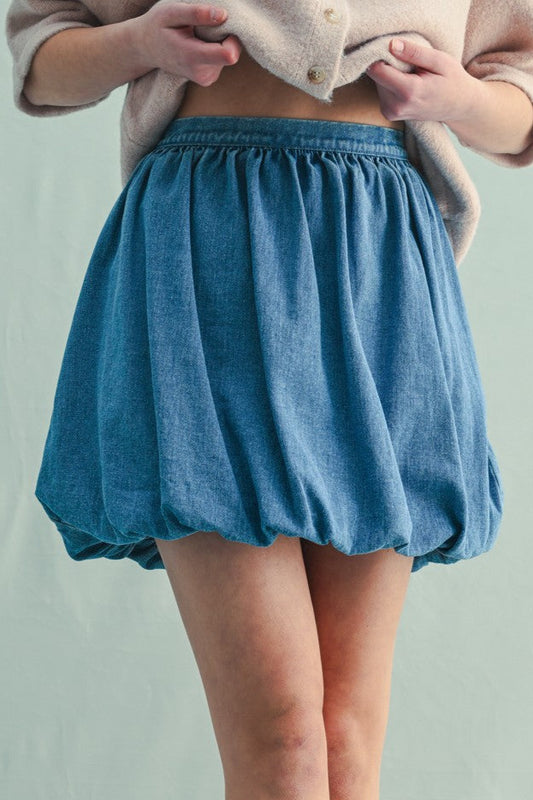 Person wearing a blue skirt on a plain background