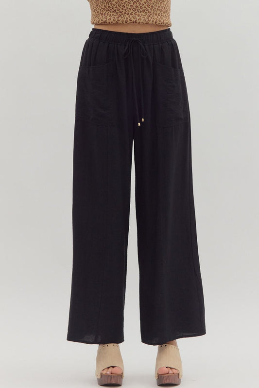 Black wide-leg pants worn by a person on a white background