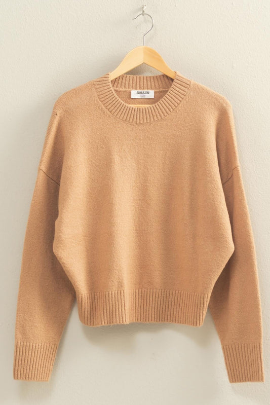 Brown sweater on a hanger against a plain background