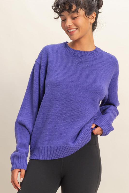 Woman wearing a blue sweater against a beige background